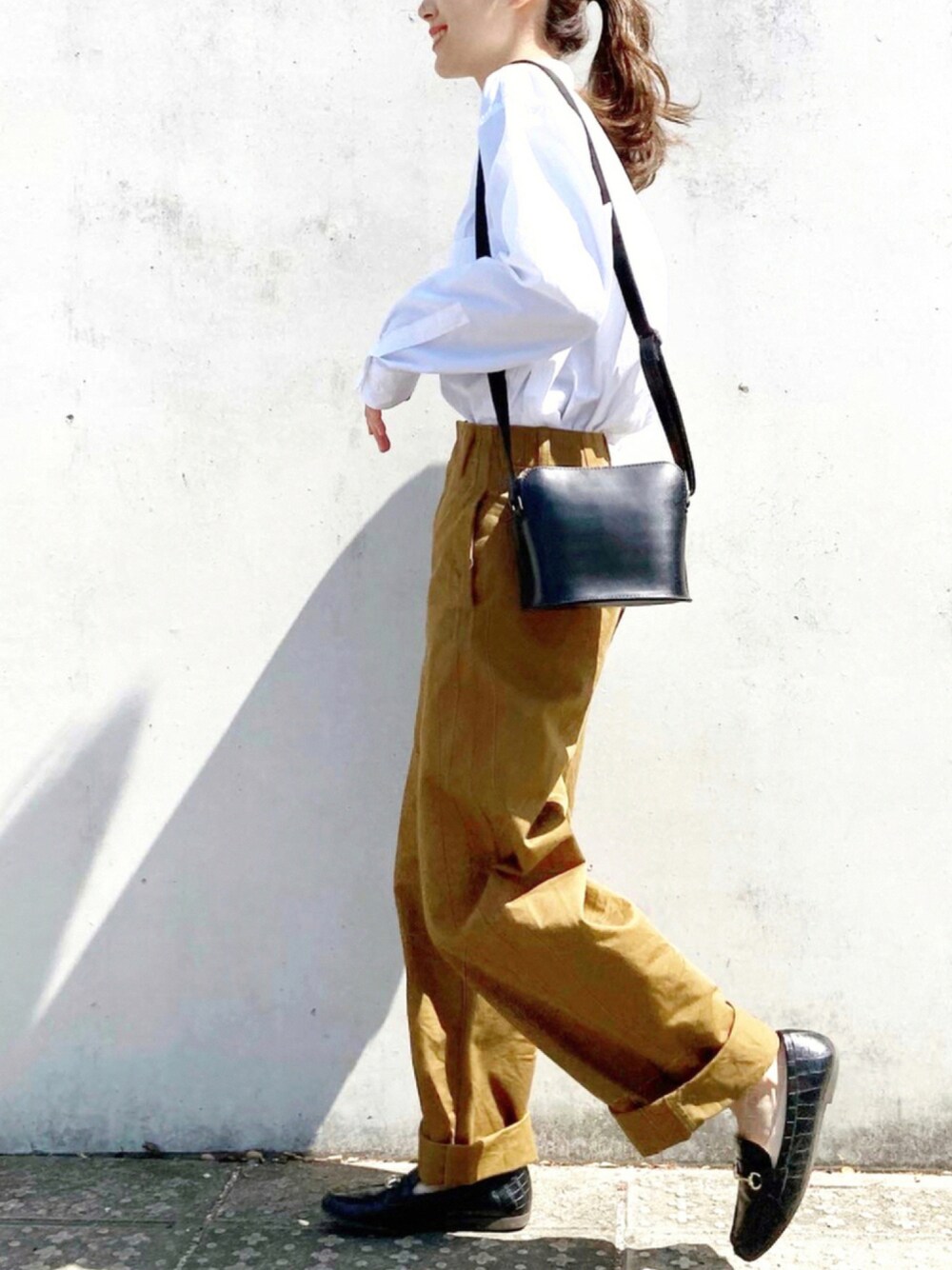 ブラック系のショルダーバッグ、ブラック系のローファー、ホワイト系のシャツ/ブラウスを着用したレディースの秋コーディネートの1枚目の写真