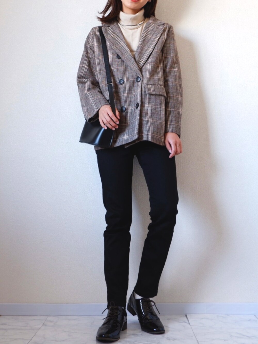 ブラック系のデニムパンツ、ブラウン系のテーラードジャケット、ベージュ系のニット/セーターを着用したレディースの秋コーディネートの1枚目の写真