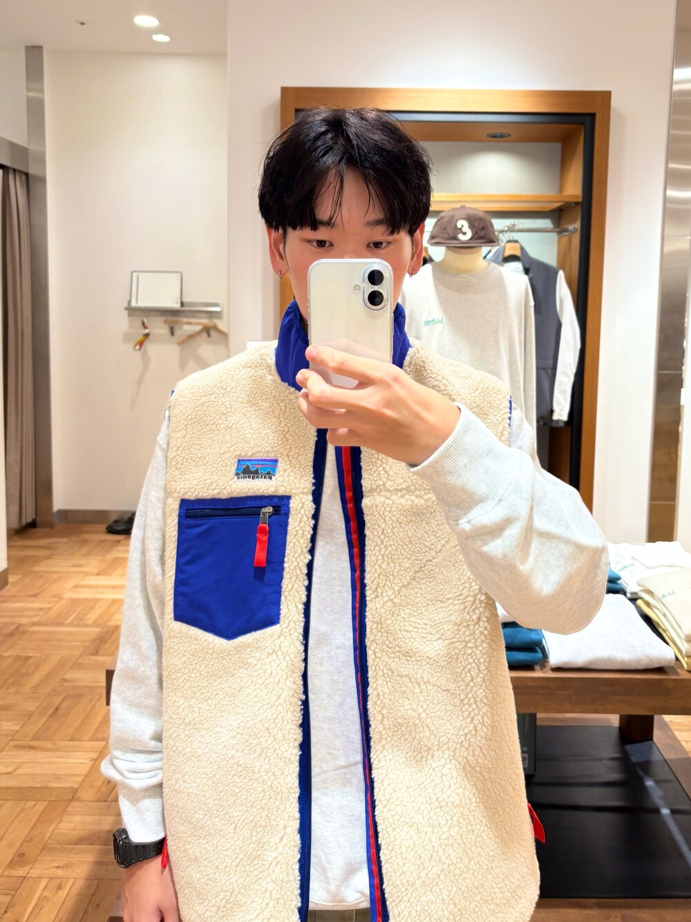 グレー系のスウェット、ベージュ系のベストを着用したメンズの秋コーディネートの1枚目の写真