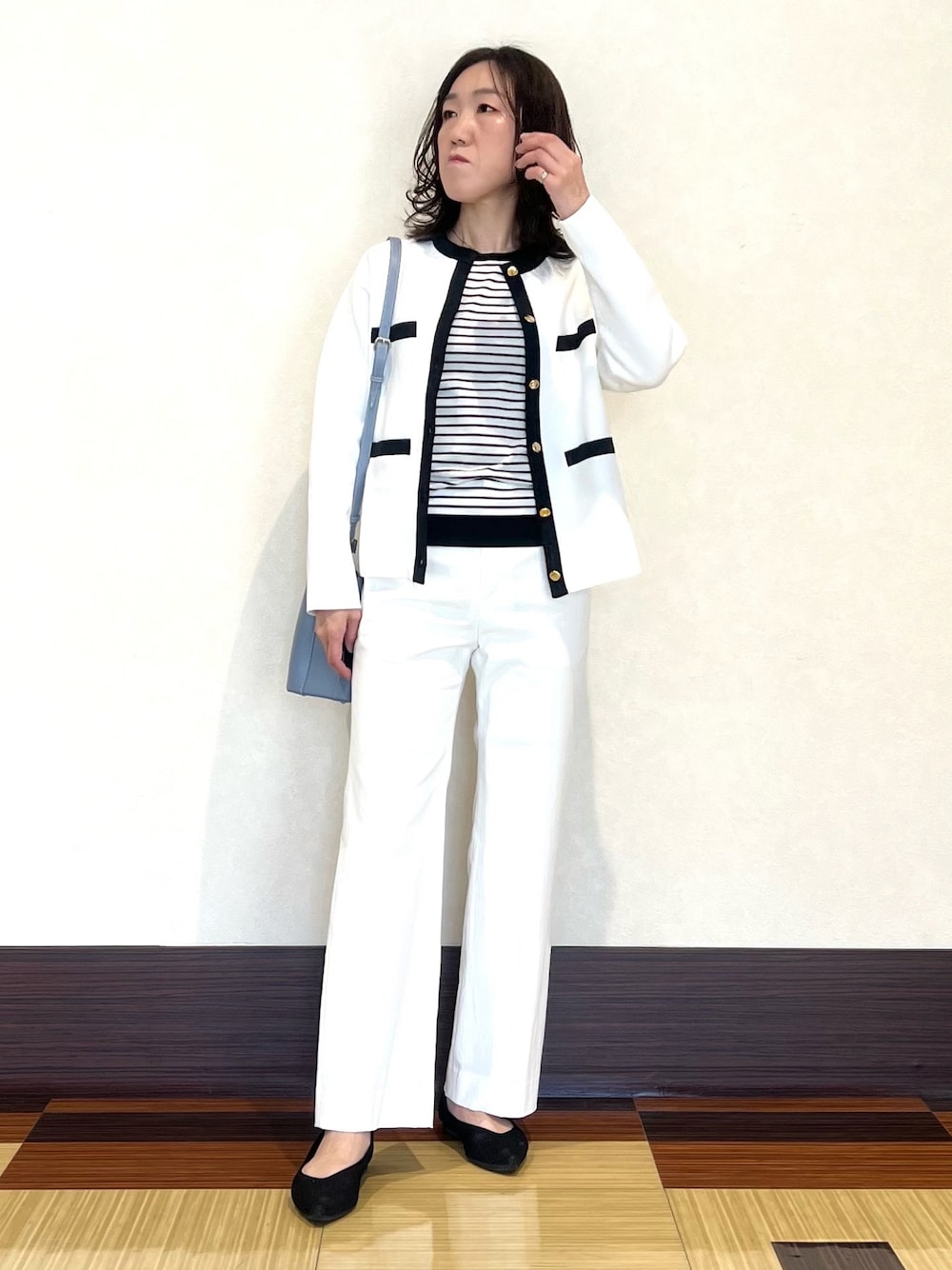 ホワイト系のカーディガン/ボレロ、ホワイト系のニット/セーター、ホワイト系のスーツパンツを着用したレディースの春コーディネートの1枚目の写真