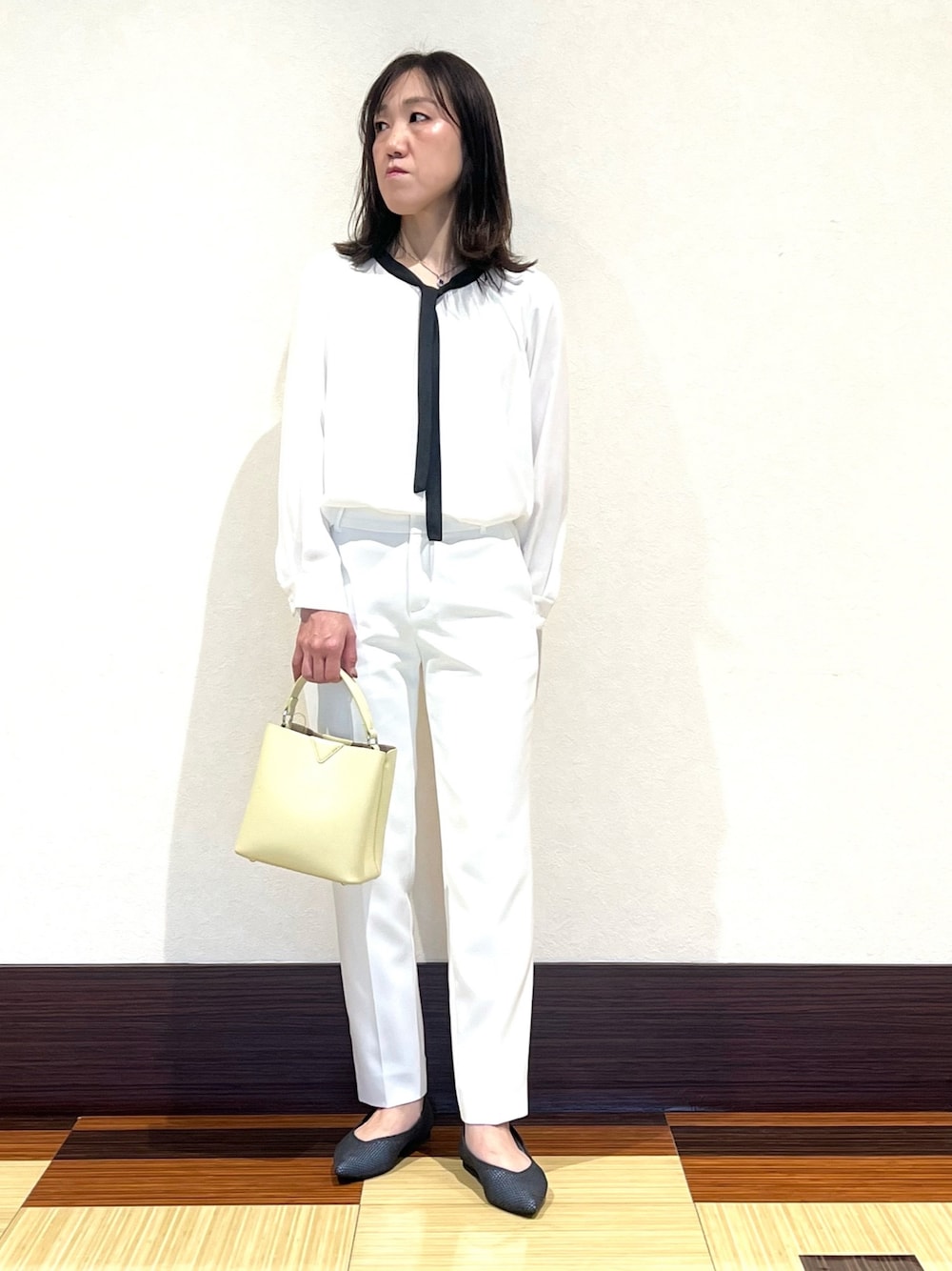 ホワイト系のシャツ/ブラウス、ホワイト系のその他パンツ、ベージュ系のショルダーバッグを着用したレディースの春コーディネートの1枚目の写真