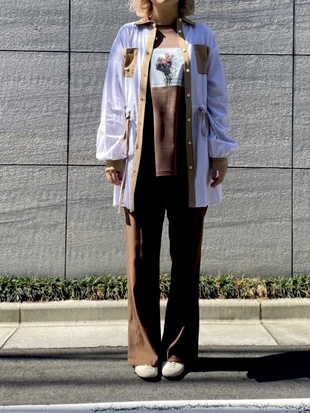 ブラウン系のスラックス、ブラウン系のTシャツ/カットソー、ベージュ系のシャツ/ブラウスを着用したレディースの春コーディネートの1枚目の写真