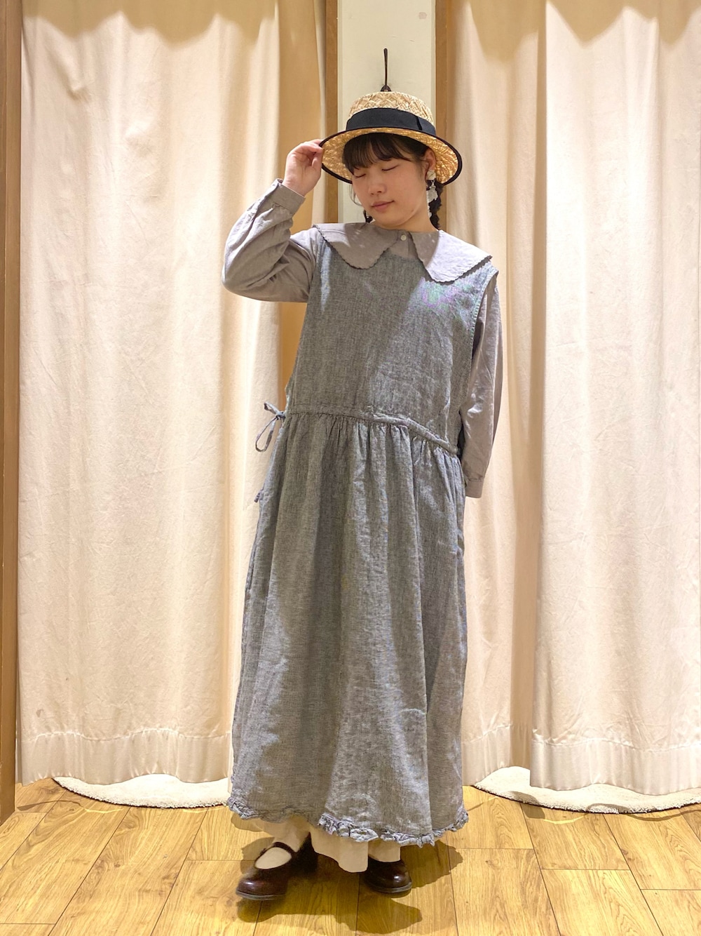 グレー系のシャツ/ブラウス、グレー系のスカート、ブラック系のワンピースを着用したレディースの春コーディネートの1枚目の写真