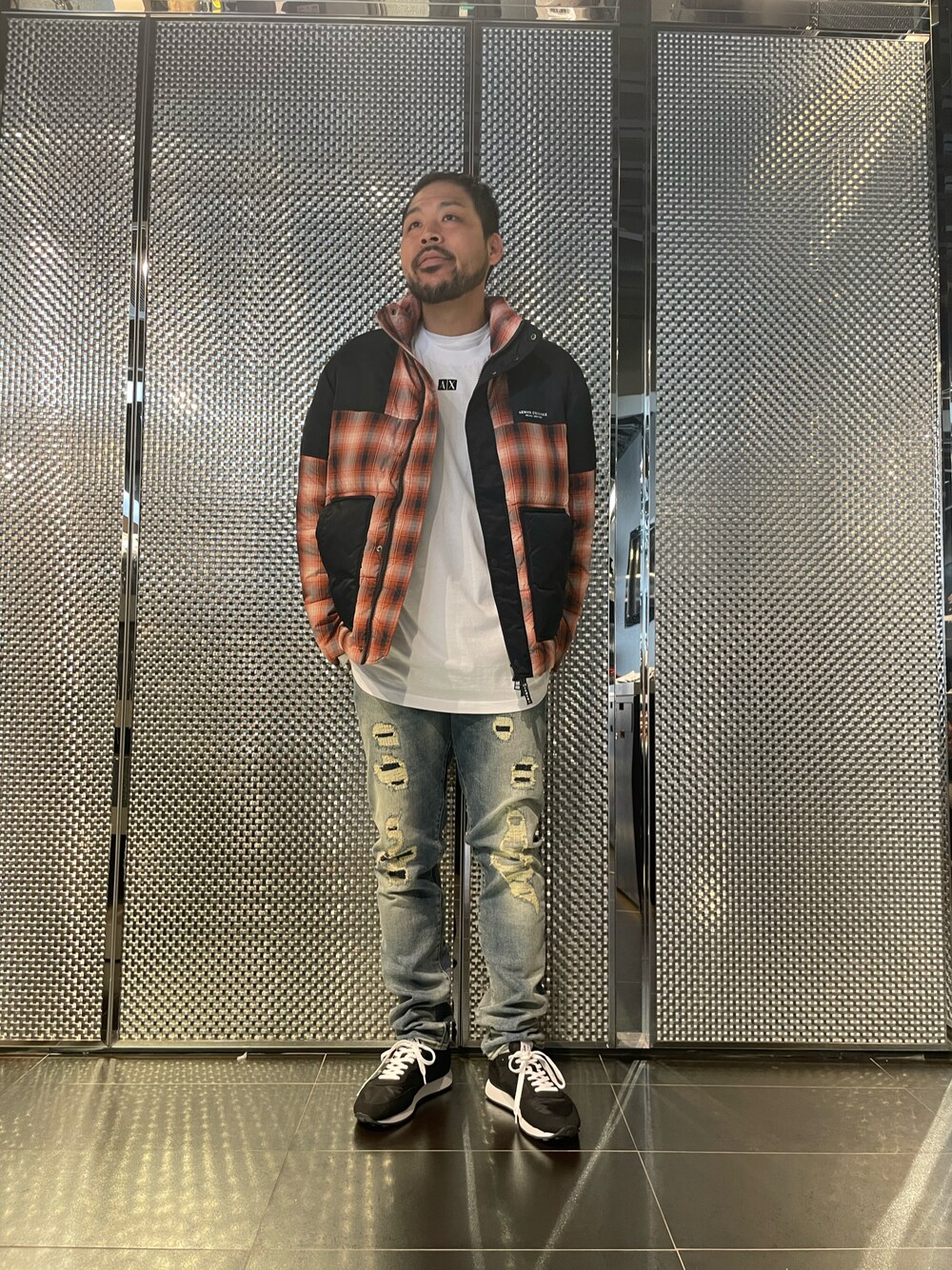 レッド系のダウンジャケット/コート、ホワイト系のTシャツ/カットソー、ブルー系のデニムパンツを着用したメンズの秋コーディネートの1枚目の写真