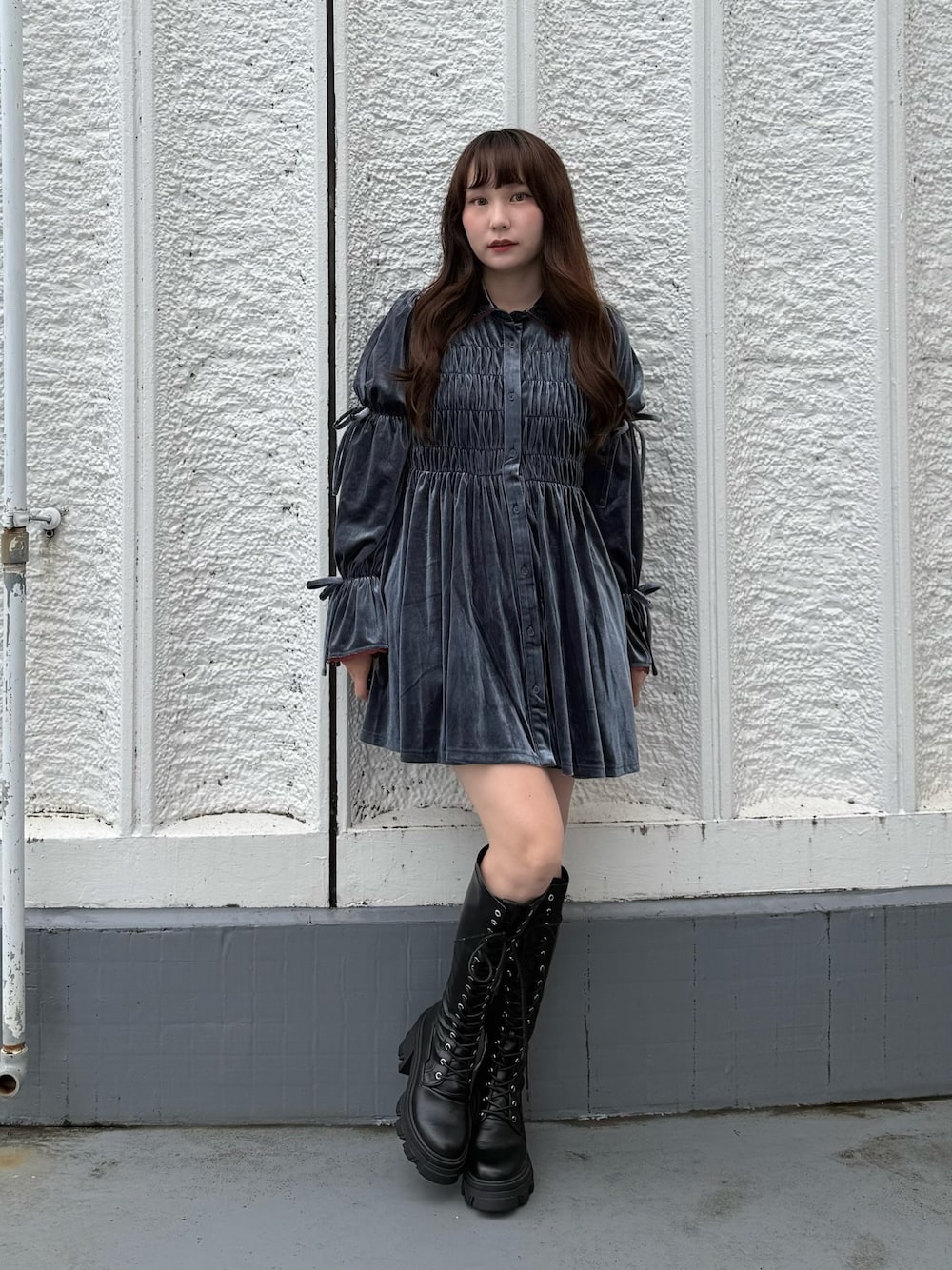 ブルー系のワンピース、ブラック系のブーツを着用したレディースの秋コーディネートの1枚目の写真
