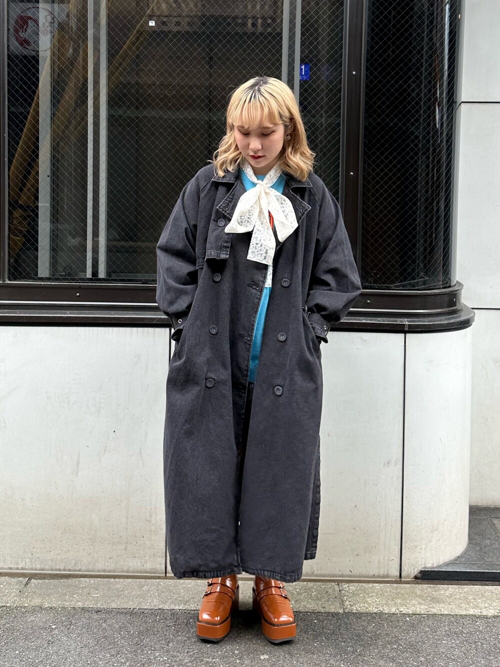 ブラウン系のブーツ、ブラック系のトレンチコート、ブルー系のスウェットを着用したレディースの冬コーディネートの1枚目の写真