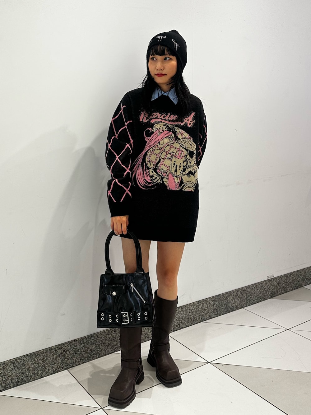 ブラック系のニット/セーター、ブラウン系のブーツ、ブルー系のシャツ/ブラウスを着用したレディースの秋コーディネートの1枚目の写真