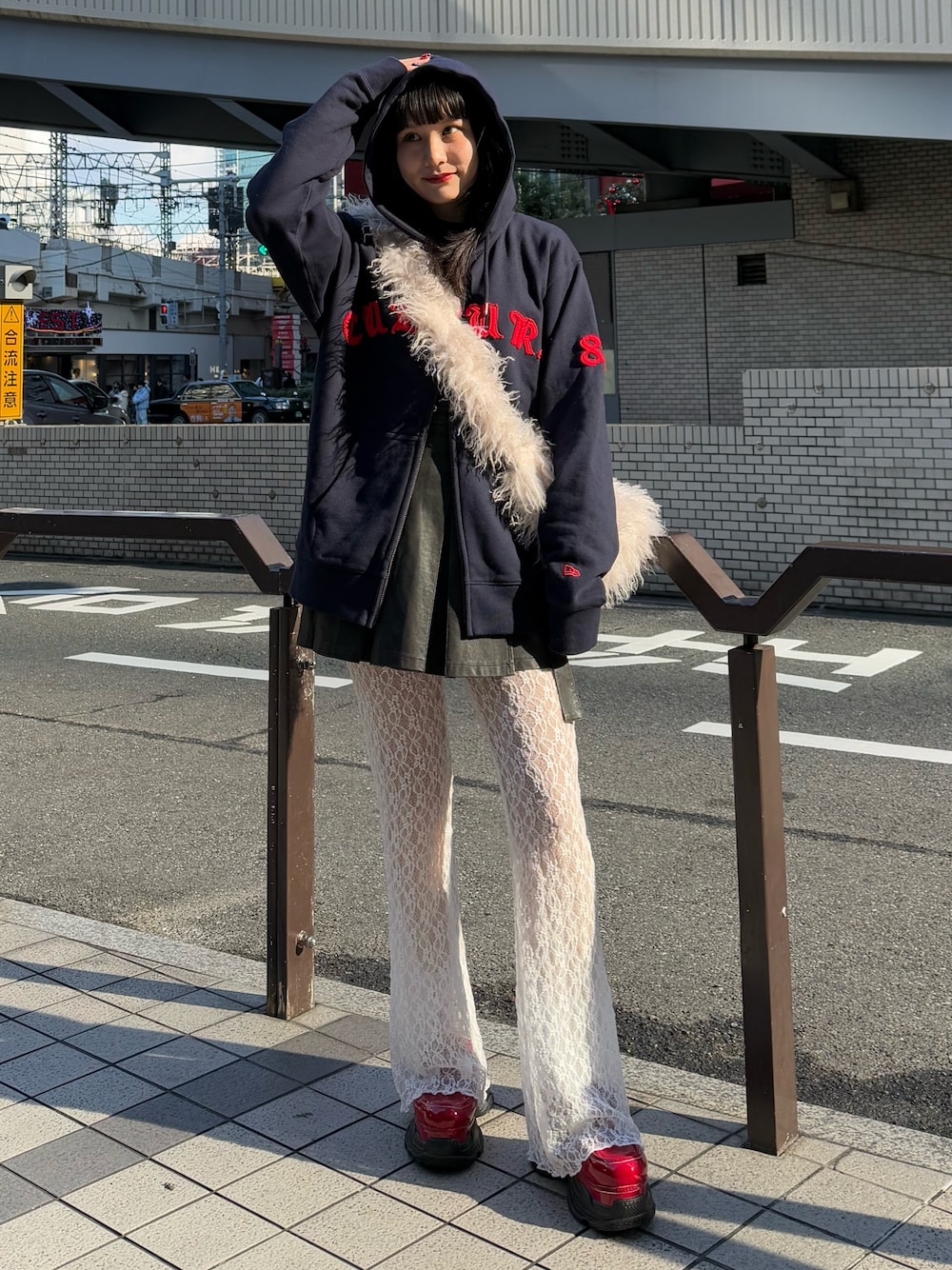 ブルー系のパーカー、ホワイト系のショルダーバッグ、ブラック系のスカートを着用したレディースの冬コーディネートの1枚目の写真