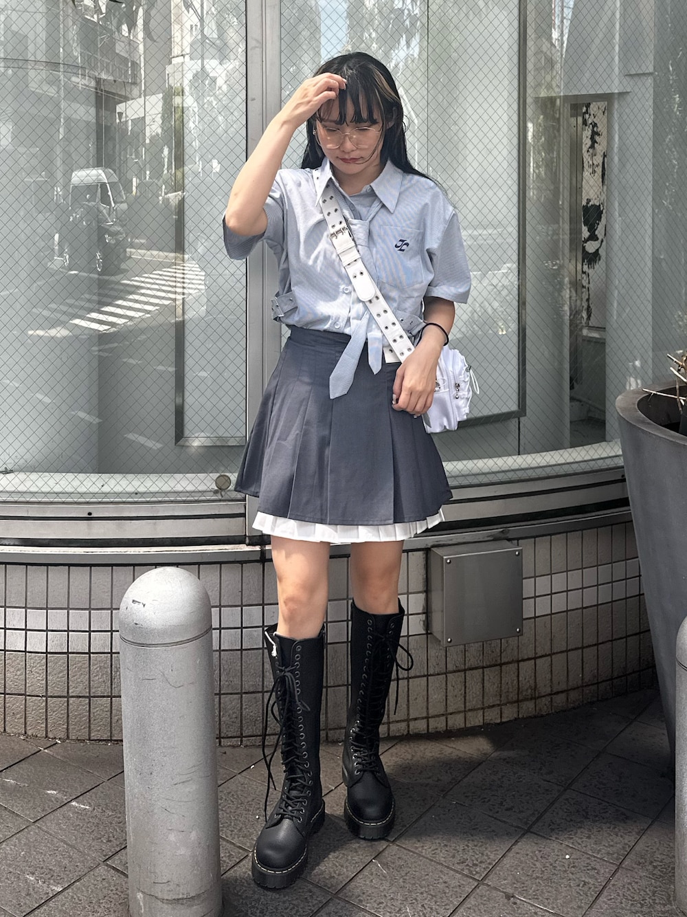 グレー系のスカート、ホワイト系のショルダーバッグ、ブルー系のシャツ/ブラウスを着用したレディースの夏コーディネートの1枚目の写真