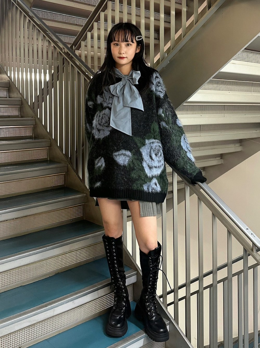 グレー系のスカート、ブラック系のニット/セーター、ブルー系のシャツ/ブラウスを着用したレディースの秋コーディネートの1枚目の写真