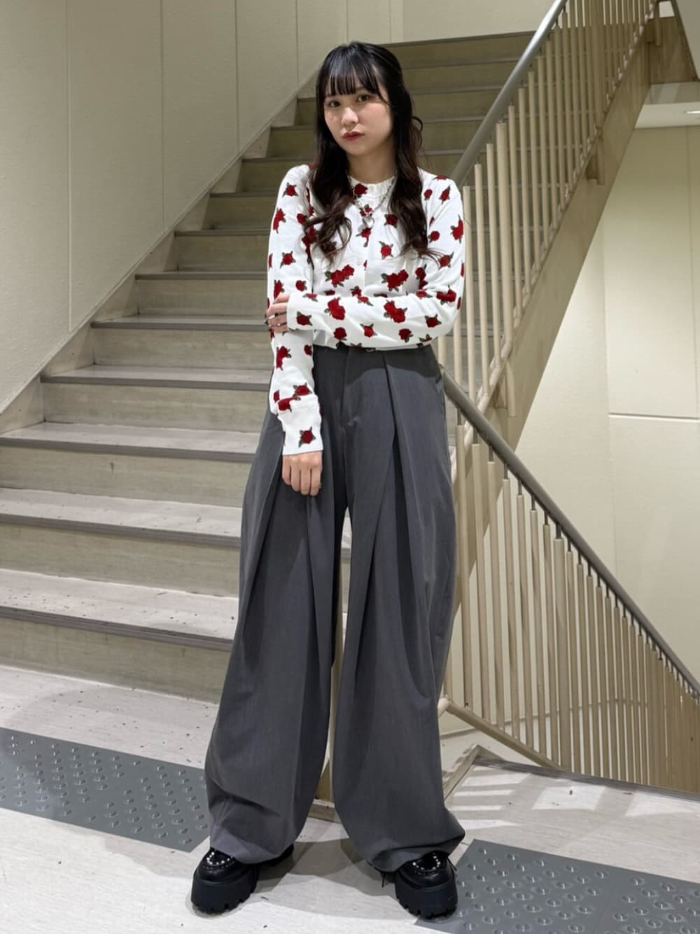 グレー系のスラックス、ホワイト系のカーディガン/ボレロ、ブラック系のローファーを着用したレディースの冬コーディネートの1枚目の写真