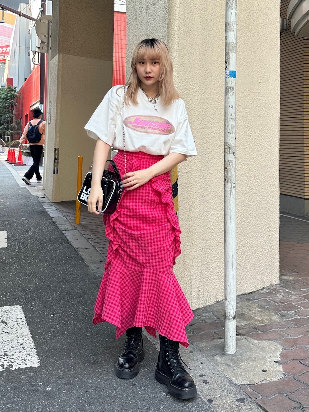 ブラック系のブーツ、ホワイト系のTシャツ/カットソー、ピンク系のスカートを着用したレディースの春コーディネートの1枚目の写真