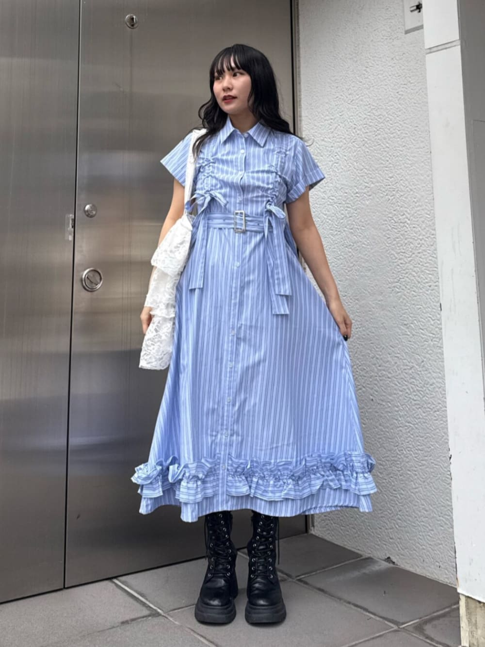 ブラック系のブーツ、ブルー系のワンピース、ホワイト系のトートバッグを着用したレディースの春コーディネートの1枚目の写真