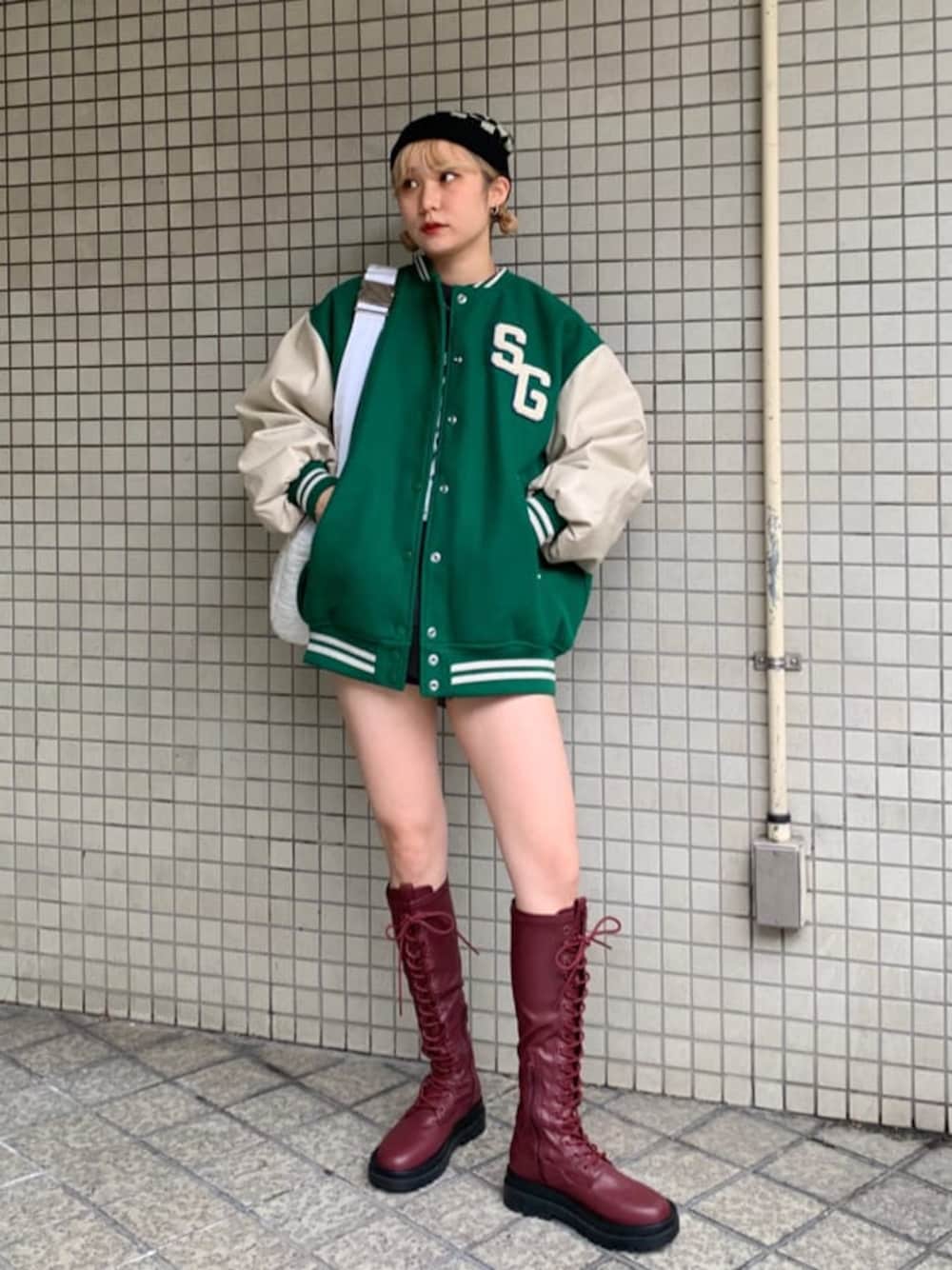 ブラック系のデニムパンツ、ブラック系のデニムパンツ、グリーン系のスタジャンを着用したレディースの秋コーディネートの1枚目の写真