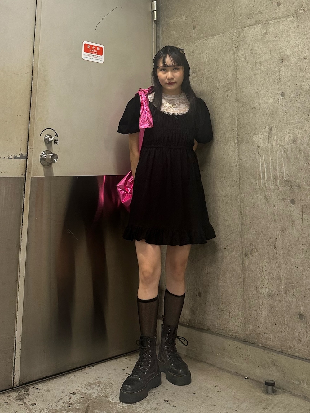 ピンク系のトートバッグ、ブラック系のワンピース、ホワイト系のTシャツ/カットソーを着用したレディースの夏コーディネートの1枚目の写真