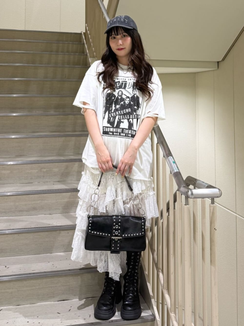 ブラック系のブーツ、ホワイト系のTシャツ/カットソー、ブラック系のハンドバッグを着用したレディースの春コーディネートの1枚目の写真