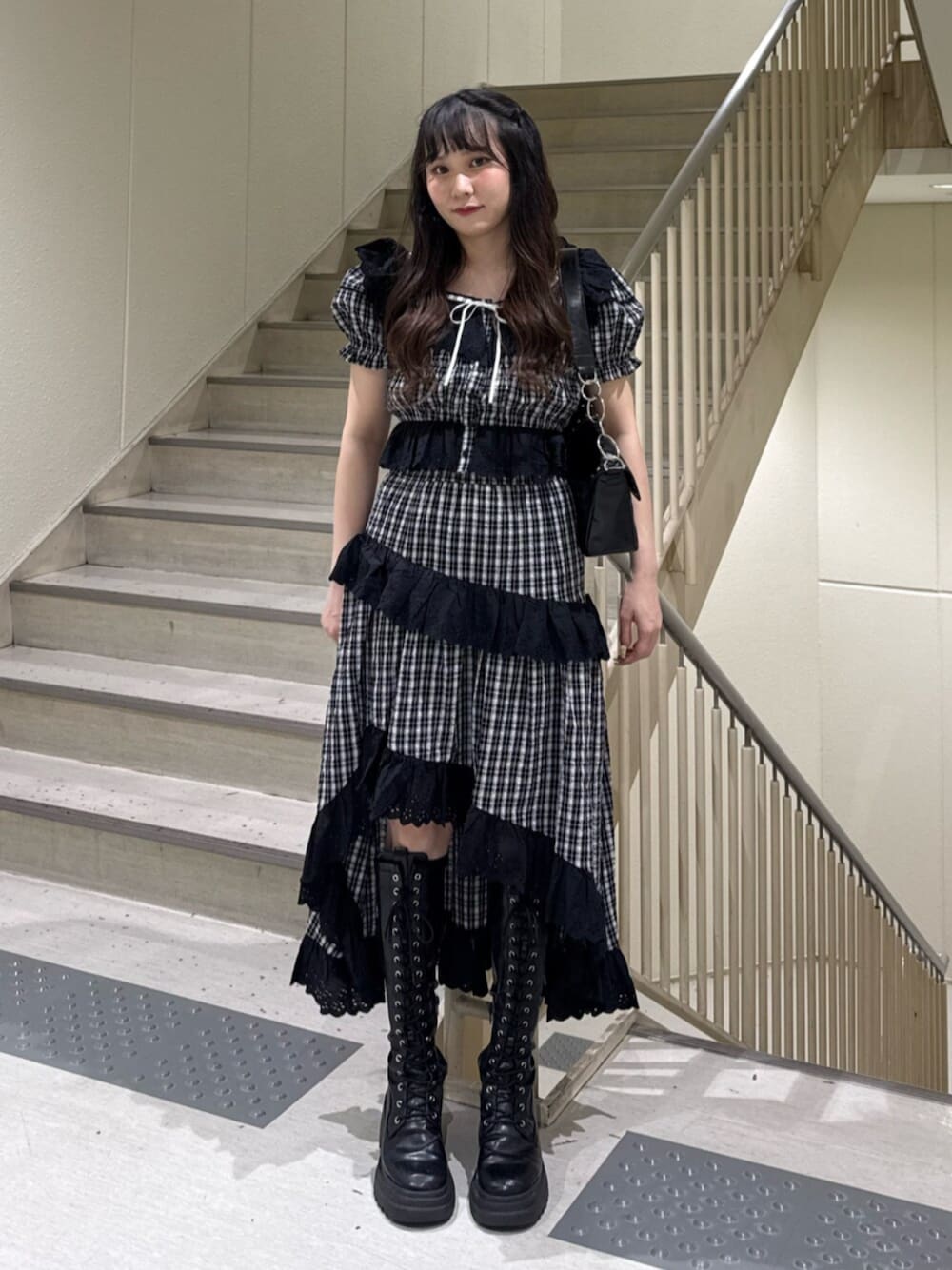 ブラック系のブーツ、ブラック系のハンドバッグ、ブラック系のシャツ/ブラウスを着用したレディースの春コーディネートの1枚目の写真