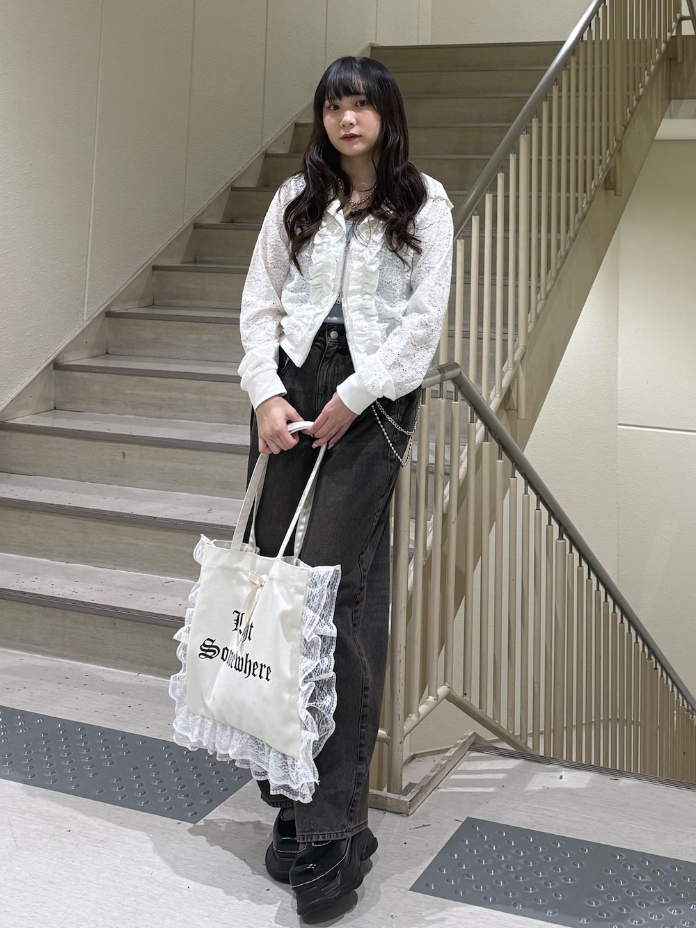 ホワイト系のパーカー、ブラック系のデニムパンツ、ホワイト系のトートバッグを着用したレディースの春コーディネートの1枚目の写真