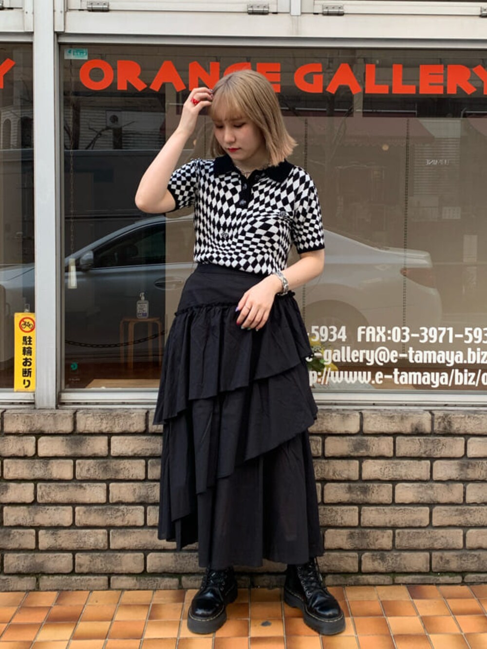 ブラック系のニット/セーター、ブラック系のスカート、シルバー系のブレスレットを着用したレディースの春コーディネートの1枚目の写真