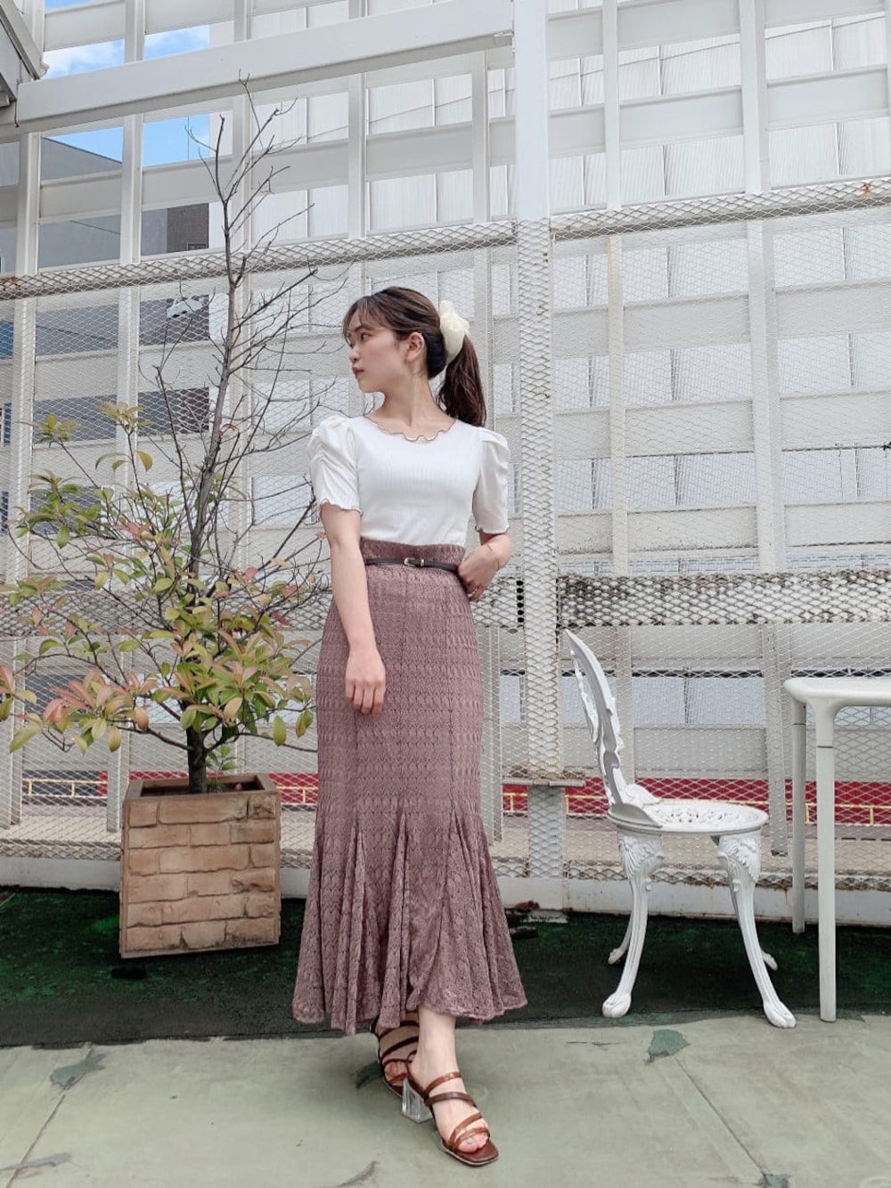 ベージュ系のスカート、ホワイト系のTシャツ/カットソー、ブラウン系のサンダルを着用したレディースの夏コーディネートの1枚目の写真