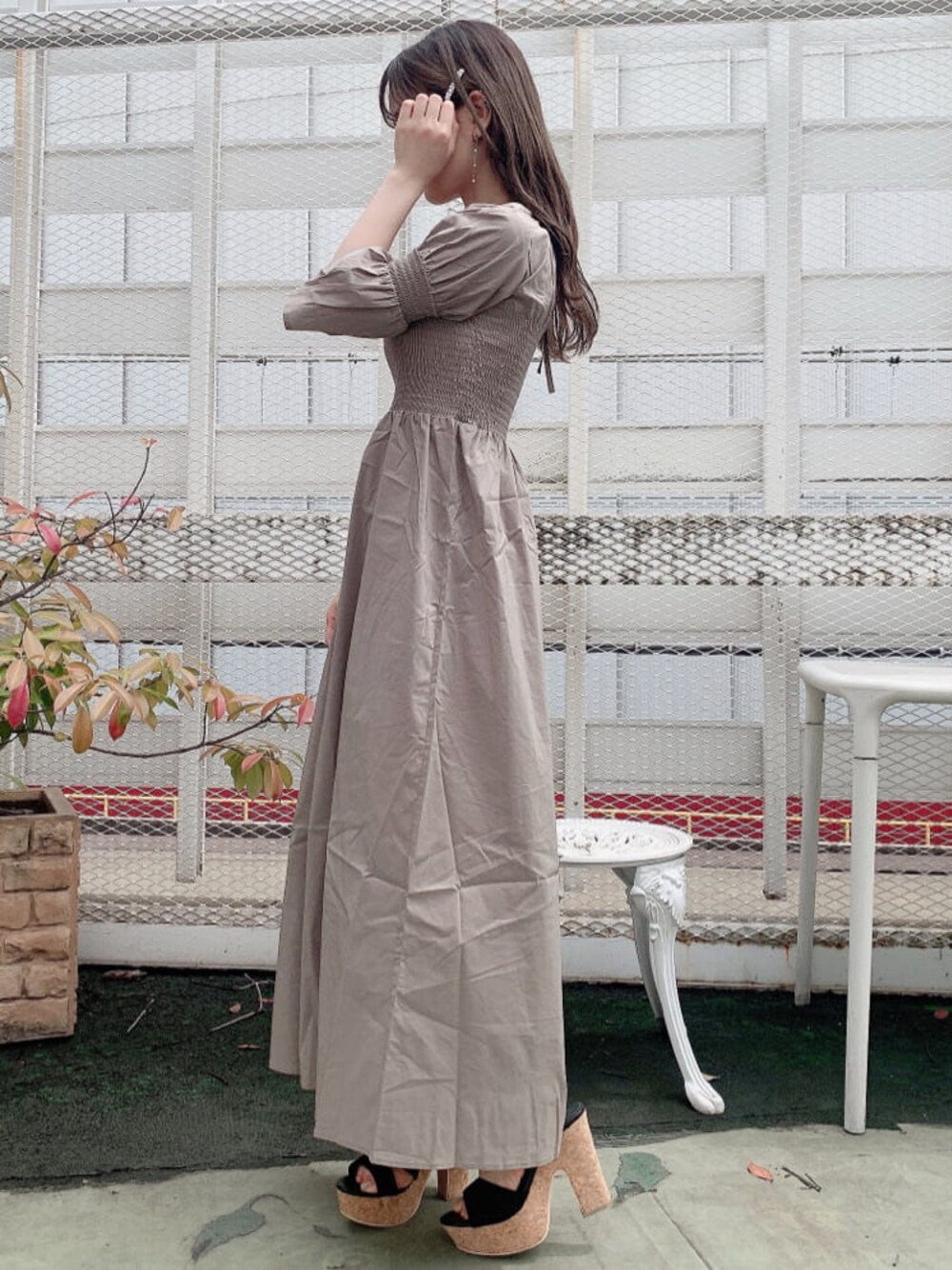 ブラック系のサンダル、ベージュ系のワンピースを着用したレディースの夏コーディネートの1枚目の写真