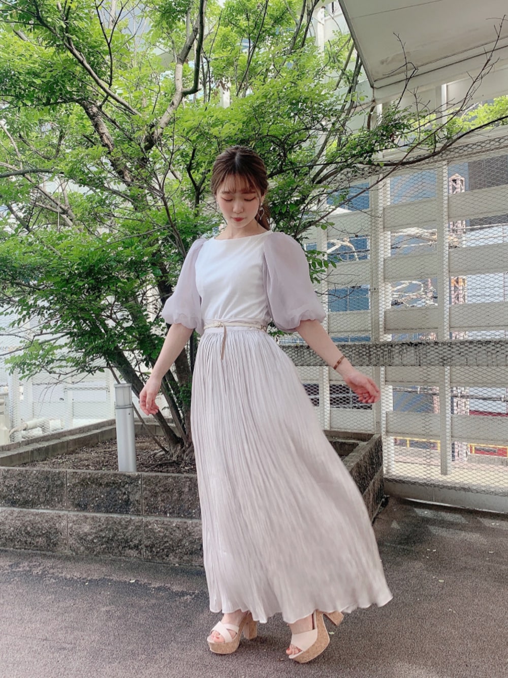 ベージュ系のサンダル、グレー系のスカート、ホワイト系のTシャツ/カットソーを着用したレディースの春コーディネートの1枚目の写真