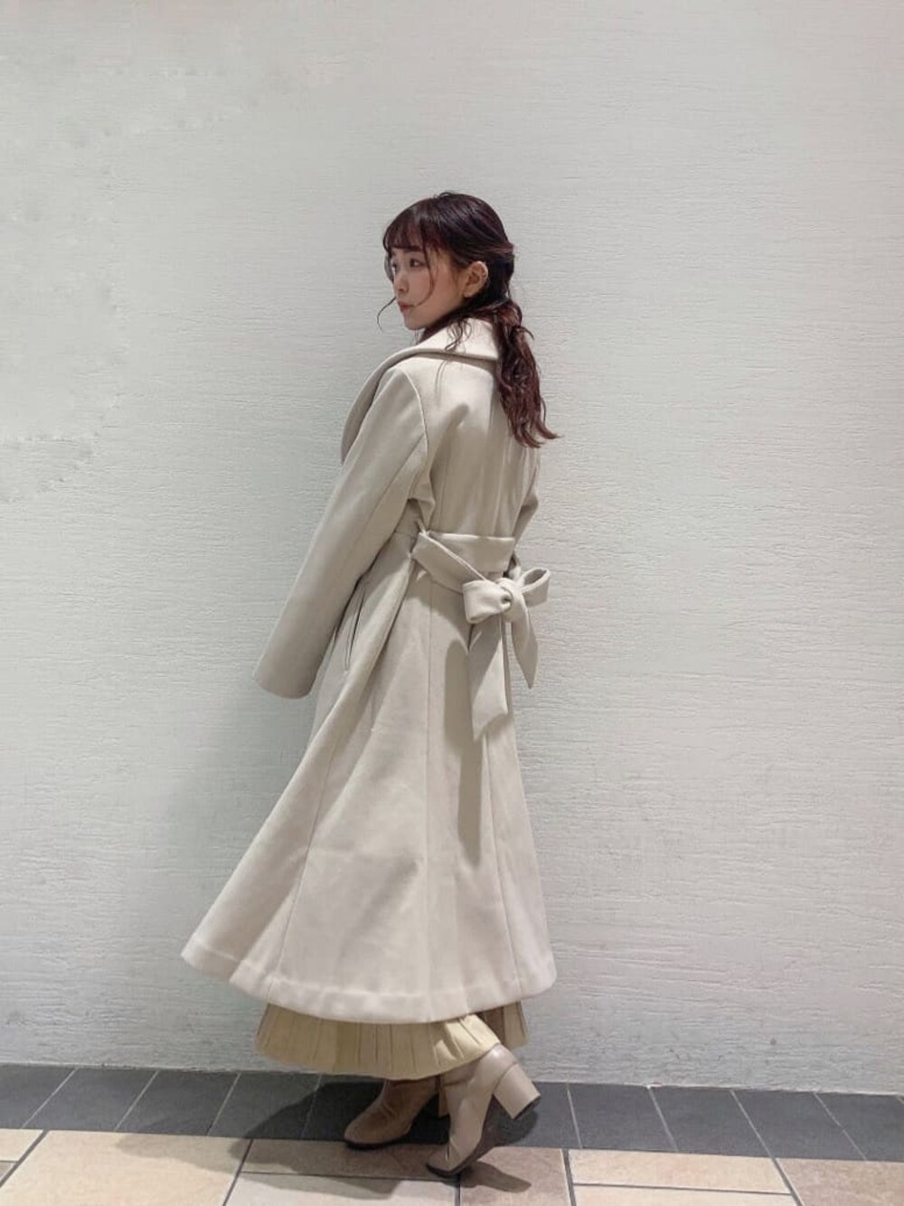 ホワイト系のその他アウター、ベージュ系のブーツ、ベージュ系のワンピースを着用したレディースの冬コーディネートの1枚目の写真