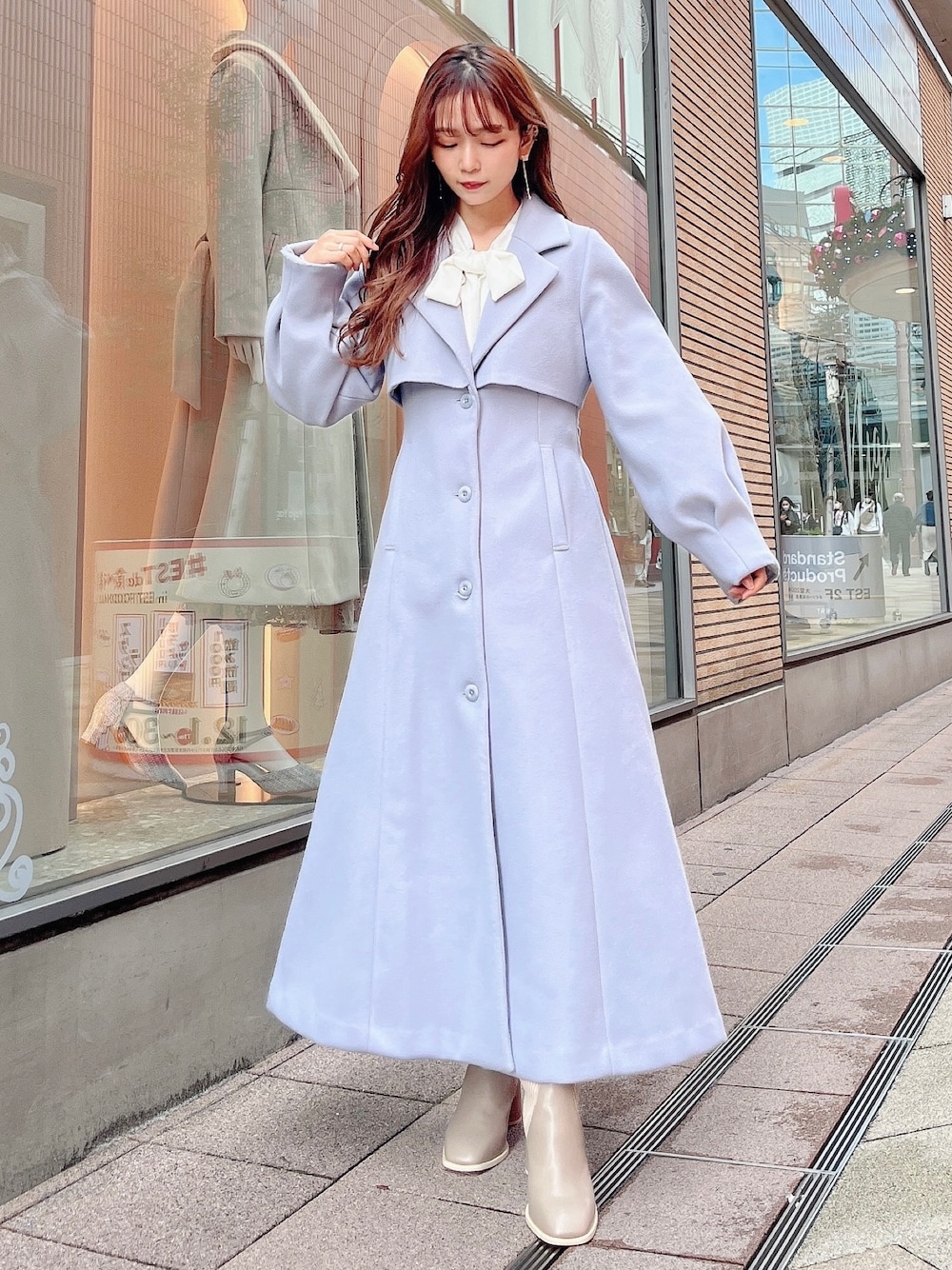 グレー系のニット/セーター、グレー系のスカート、ブルー系のその他アウターを着用したレディースの冬コーディネートの1枚目の写真