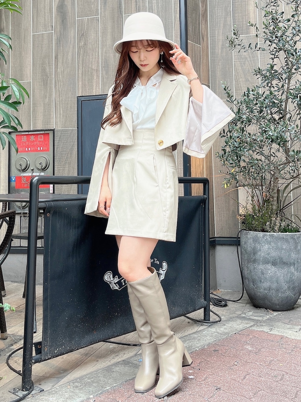 ベージュ系のテーラードジャケット、ホワイト系のニット/セーター、ベージュ系のスカートを着用したレディースの冬コーディネートの1枚目の写真