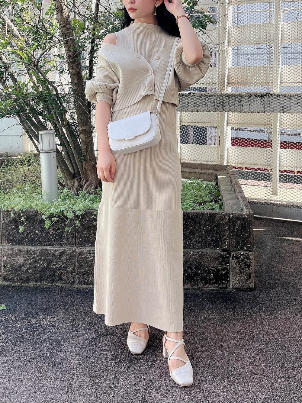 ホワイト系のパンプス、ホワイト系のショルダーバッグ、ベージュ系のワンピースを着用したレディースの春コーディネートの1枚目の写真