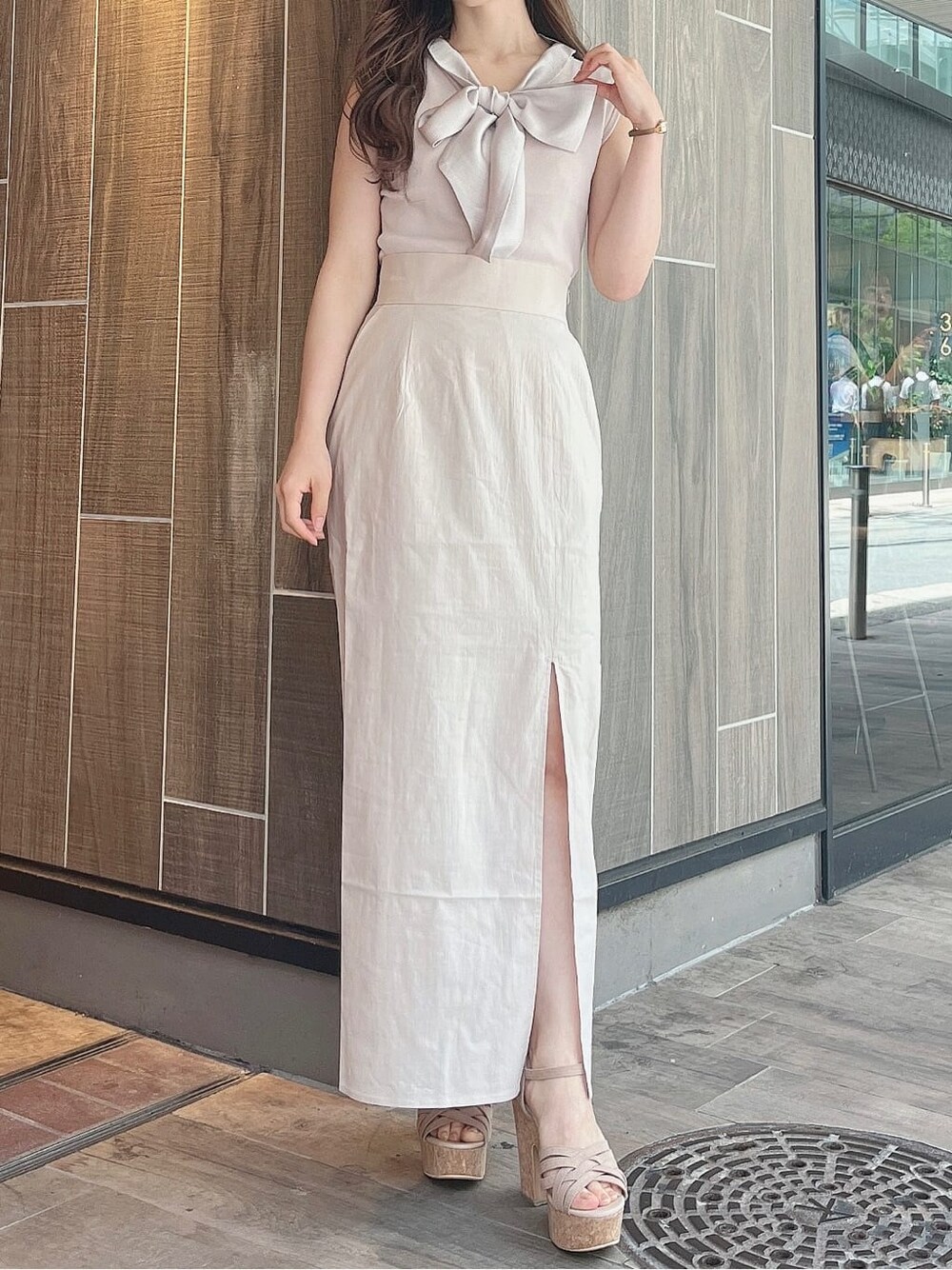 ベージュ系のサンダル、グレー系のニット/セーター、ベージュ系のスカートを着用したレディースの夏コーディネートの1枚目の写真