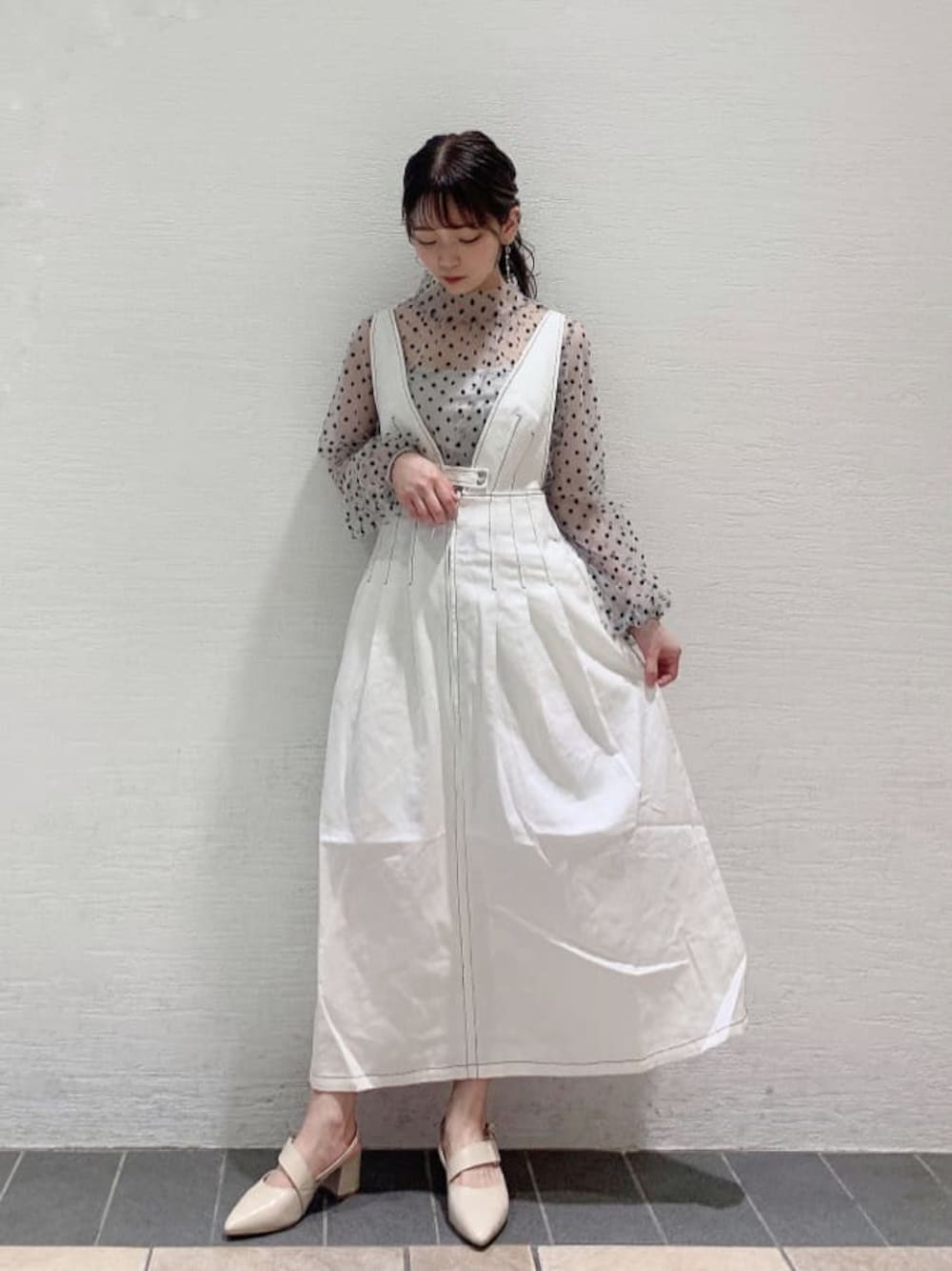 ホワイト系のジャンパースカート、ホワイト系のシャツ/ブラウス、ホワイト系のパンプスを着用したレディースの夏コーディネートの1枚目の写真