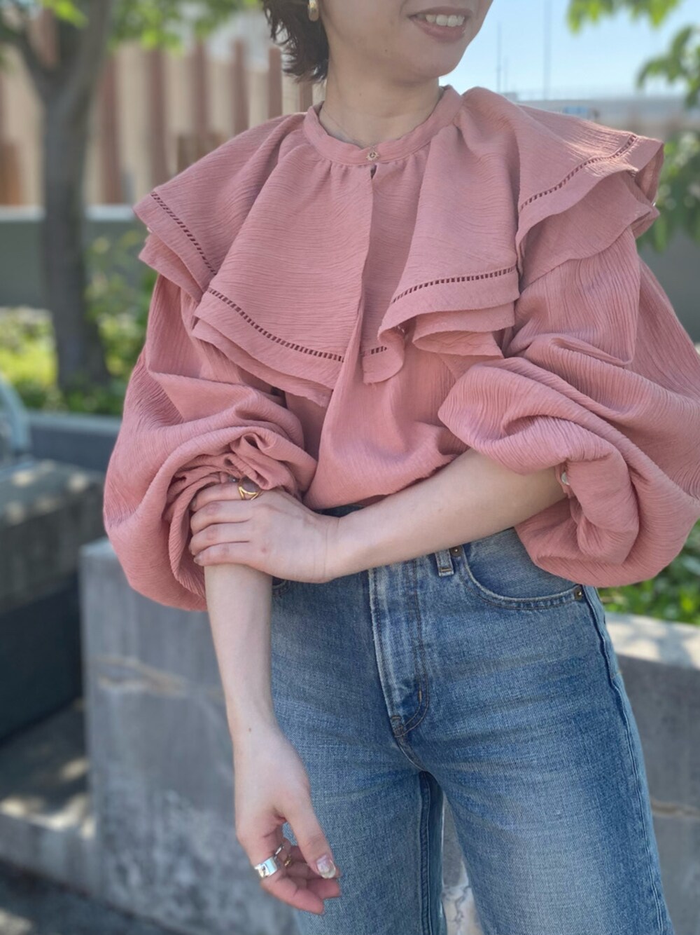 ブラック系のハンドバッグ、ブルー系のデニムパンツ、ピンク系のシャツ/ブラウスを着用したレディースの春コーディネートの1枚目の写真