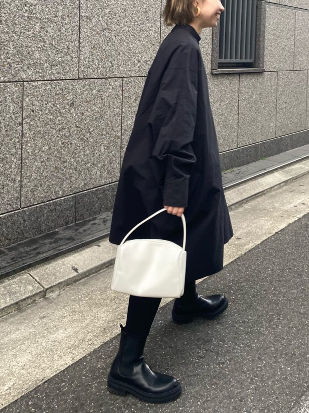 ベージュ系のトレンチコート、ブラック系のシャツ/ブラウス、ホワイト系のハンドバッグを着用したレディースの冬コーディネートの1枚目の写真