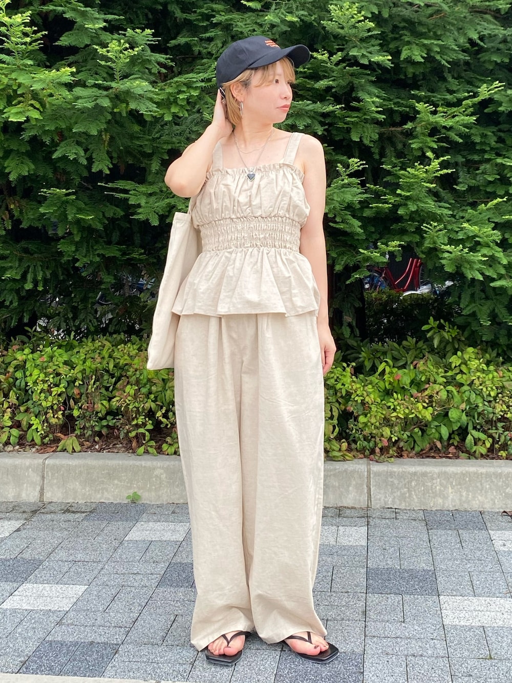 ホワイト系のキャミソール、ホワイト系のその他パンツ、ブラック系のサンダルを着用したレディースの夏コーディネートの1枚目の写真
