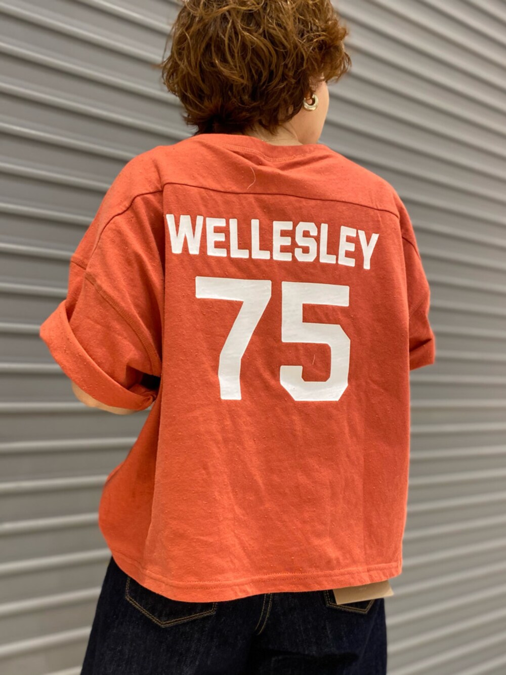 ブルー系のデニムパンツ、オレンジ系のTシャツ/カットソーを着用したレディースの春コーディネートの1枚目の写真