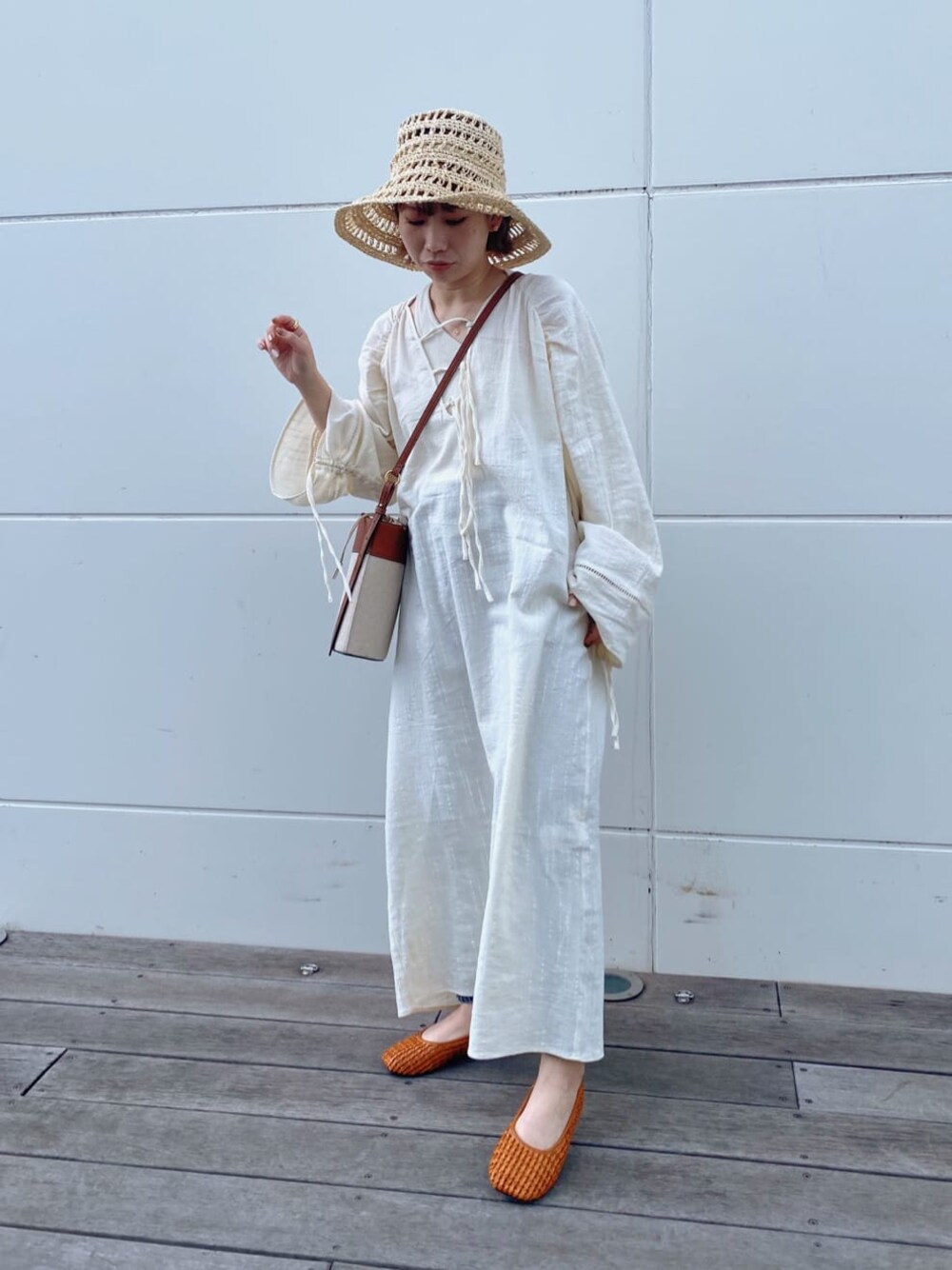 ブラウン系のパンプス、ブラウン系のショルダーバッグ、ホワイト系のタンクトップを着用したレディースの春コーディネートの1枚目の写真