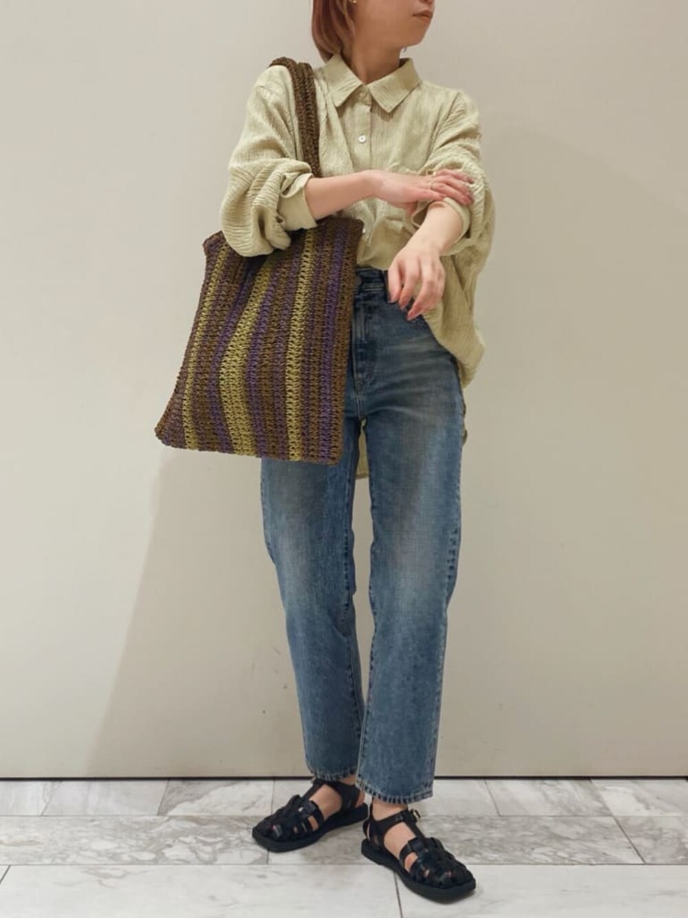 ベージュ系のトレンチコート、ブラウン系のトートバッグ、グリーン系のシャツ/ブラウスを着用したレディースの春コーディネートの1枚目の写真