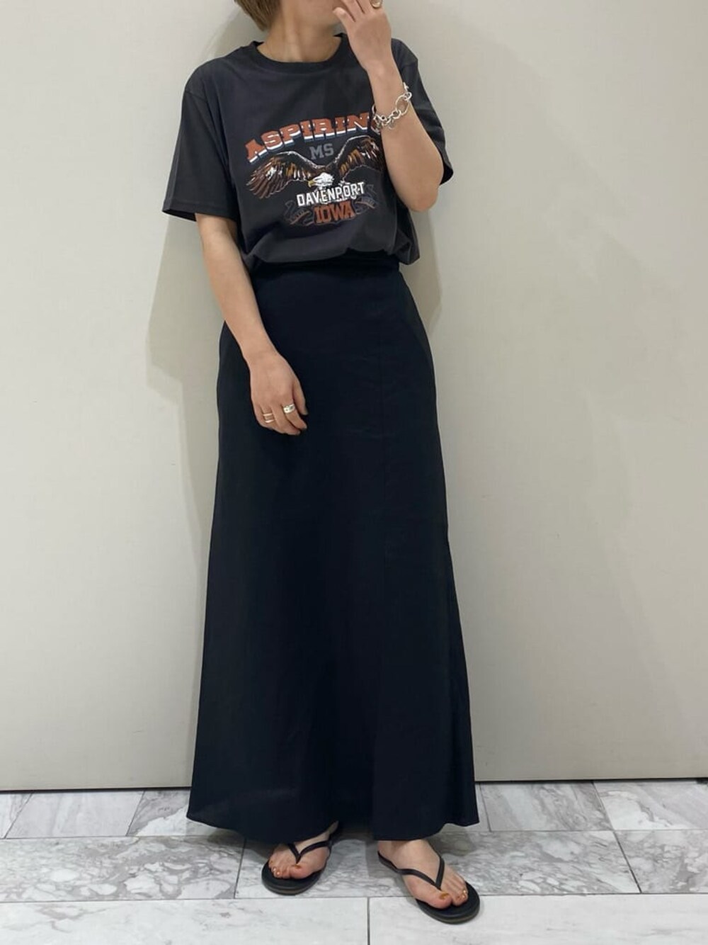 ブラック系のスカート、グレー系のTシャツ/カットソーを着用したレディースの夏コーディネートの1枚目の写真