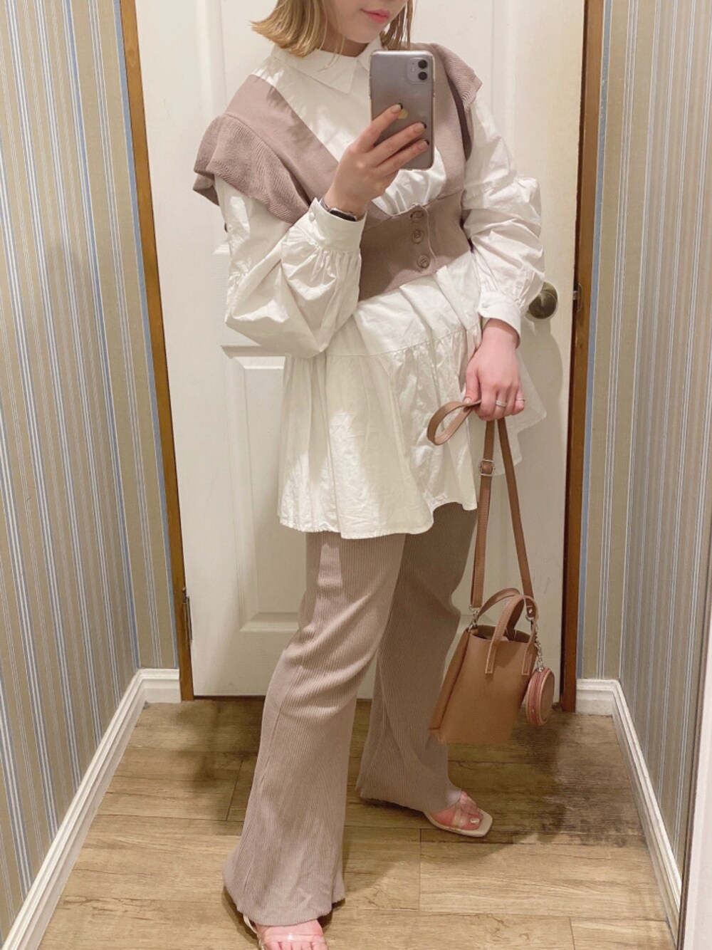 ホワイト系のシャツ/ブラウス、ベージュ系のその他パンツ、ブラウン系のハンドバッグを着用したレディースの春コーディネートの1枚目の写真