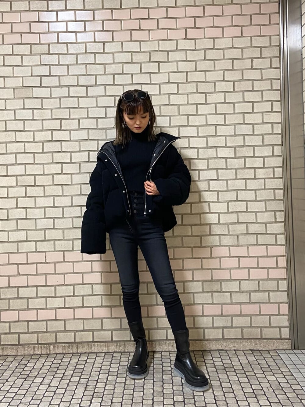ブラック系のブーツ、ブラック系のニット/セーター、ブラック系のダウンジャケット/コートを着用したレディースの冬コーディネートの1枚目の写真