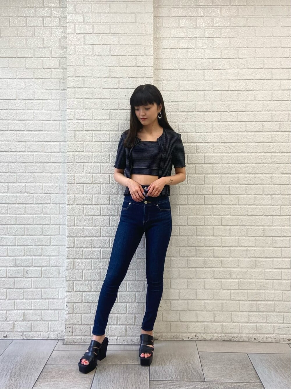 ブルー系のデニムパンツ、ブラック系のサンダル、その他のアンサンブルを着用したレディースの夏コーディネートの1枚目の写真