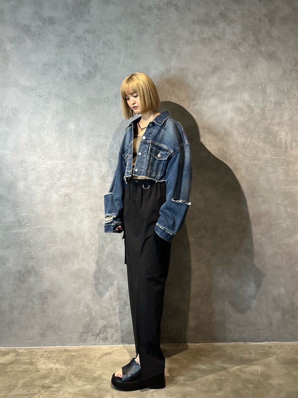 ブルー系のデニムジャケット、ベージュ系のキャミソール、ブラック系のスカートを着用したレディースの春コーディネートの1枚目の写真