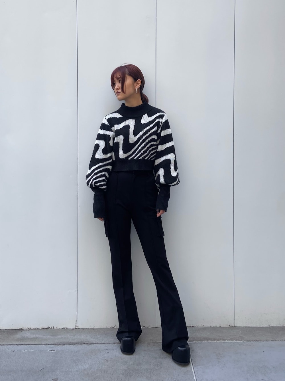 ブラック系のニット/セーター、ブラック系のカーゴパンツ、ブラック系のブーツを着用したレディースの冬コーディネートの1枚目の写真