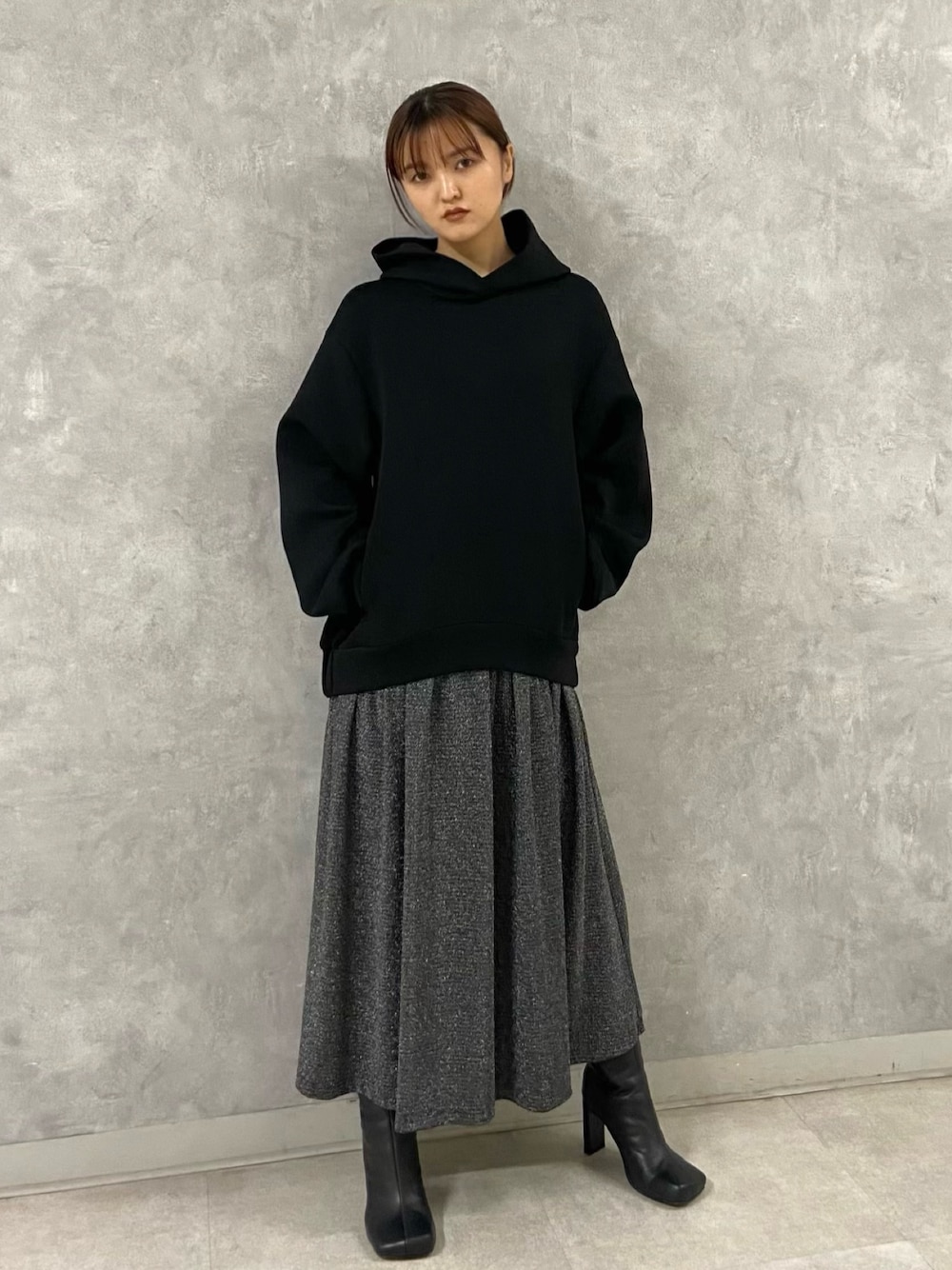 ブラック系のワンピース、ブラック系のブーツを着用したレディースの秋コーディネートの1枚目の写真