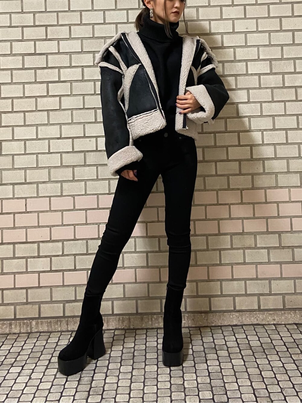 その他のムートンコート、ブラック系のブーツ、ブラック系のニット/セーターを着用したレディースの秋コーディネートの1枚目の写真