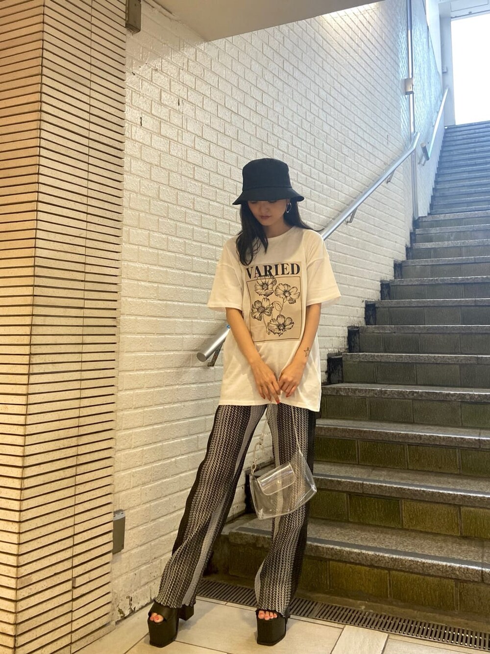 ブラック系のサンダル、その他のその他パンツ、ホワイト系のTシャツ/カットソーを着用したレディースの春コーディネートの1枚目の写真