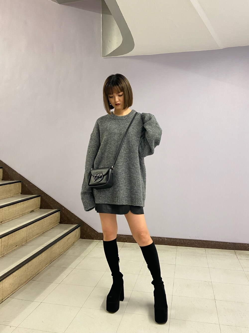 グレー系のニット/セーター、ブラック系のショルダーバッグ、その他のスカートを着用したレディースの秋コーディネートの1枚目の写真