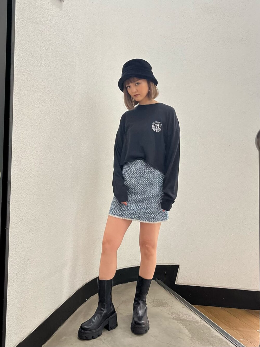 ブラック系のブーツ、グレー系のスカート、ブラック系のTシャツ/カットソーを着用したレディースの秋コーディネートの1枚目の写真