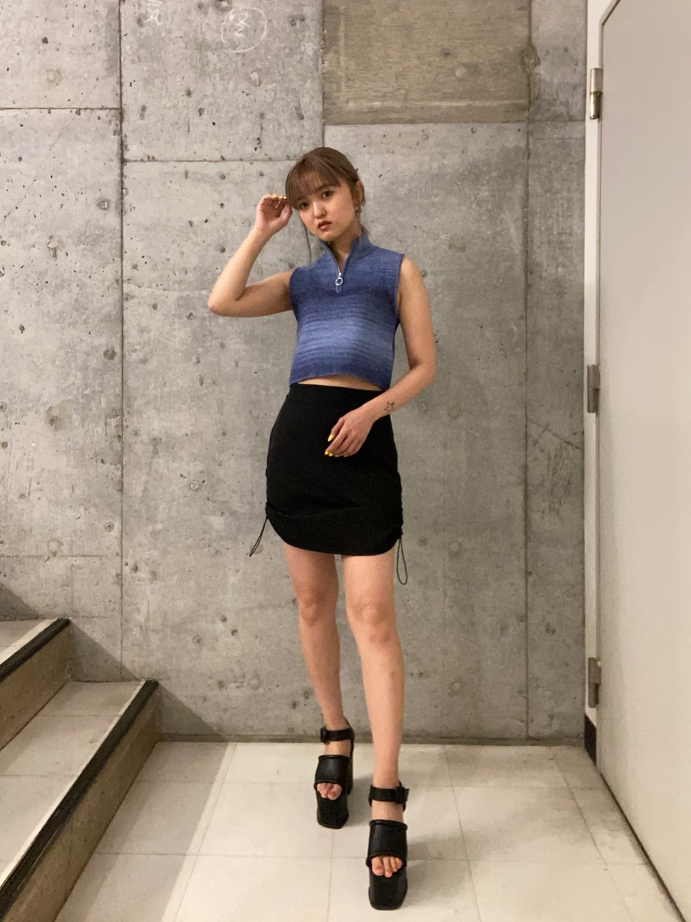 ブルー系のタンクトップ、ブラック系のスカート、ブラック系のサンダルを着用したレディースの春コーディネートの1枚目の写真